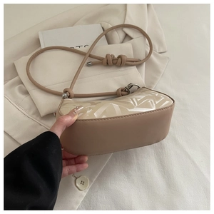 Detail of apricot PU leather shoulder bag with geometric print and knotted strap