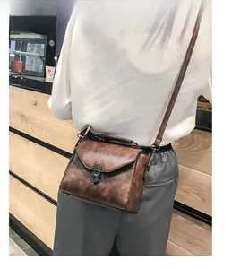 Dettaglio borsa quadrata vintage marrone con chiusura a scatto in metallo e tracolla