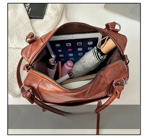 Top-down view of a spacious leather tote interior holding a tablet, umbrella, and essentials