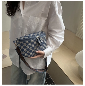 Detail of blue jacquard waist bag with gold zippers and wide patterned shoulder strap