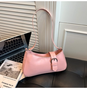 Detail of light pink baguette bag showing matte PU leather texture and silver buckle