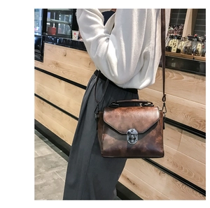 Borsa a tracolla retrò marrone caramello con chiusura a scatto su modella