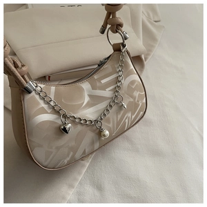 Detail of half-moon bag featuring abstract prints, silver chain, and heart pearl charms