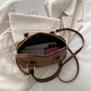 Internal view of the brown boston bag showing capacity for phone and long wallet