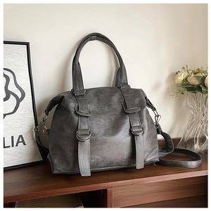 Retro grey PU leather tote bag with metal ring detail on a dark wooden table surface