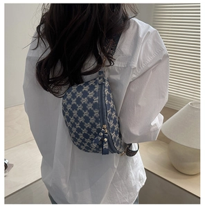 Close-up of blue monogram jacquard crossbody bag with dual metal zippers and wide strap