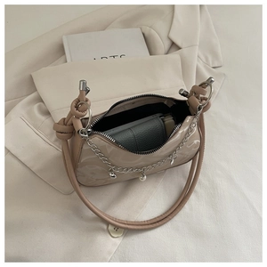 Close-up of beige PU underarm bag showing interior space and pearl chain detail