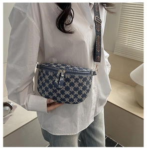 Close-up of blue jacquard fabric chest bag with 'M' pattern and vintage wide strap