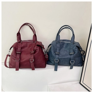 Detail of vintage faux leather tote bags in burgundy and blue with metallic D-ring accents