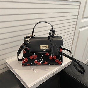 Minimalist black cherry print crossbody bag with golden clasp and leather handle