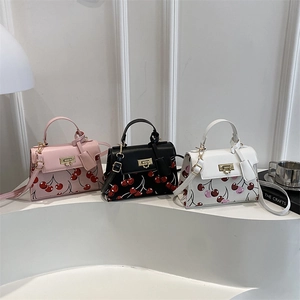 Three minimalist cherry print crossbody bags in pink, black, and white colors with gold locks