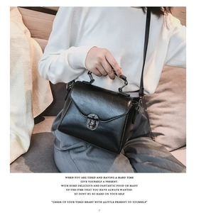 Dettaglio di una borsa a tracolla nera vintage con chiusura a scatto in metallo