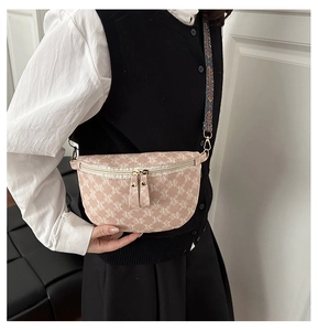 Detail of monogram fanny pack with colorful jacquard strap and gold-tone zippers