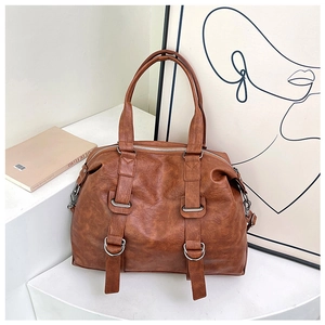 Close-up of vintage brown leather tote bag showing detailed pebble grain and silver buckles
