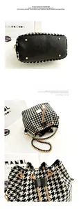 Detail view of houndstooth bucket bag bottom with black leather and protective gold studs