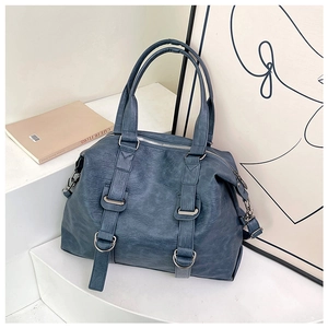 Detailed view of blue leather boston bag with textured finish and silver ring hardware