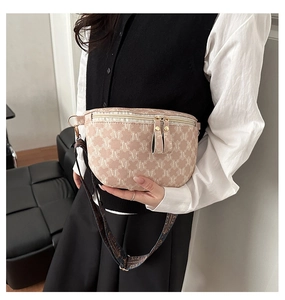 Detail of crossbody bag with double gold zippers and monogram pattern on model