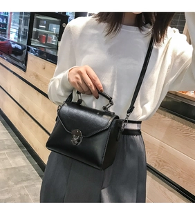 Dettaglio borsa retrò nera in pelle PU con chiusura a rotazione e manico superiore