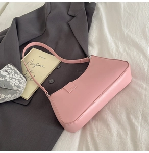 Detail of pink PU leather baguette bag with refined texture on a stylish French backdrop