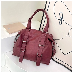 Detail of vintage burgundy tote bag with pebble texture and silver metal hardware accents