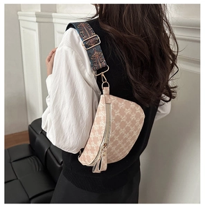 Close-up of retro plaid chest bag with monogram patterns and colorful embroidered strap