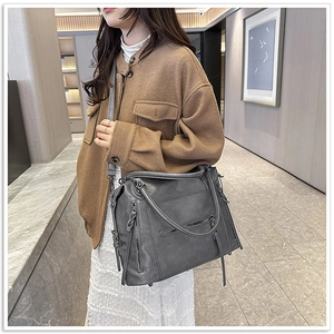 Large soft leather tote bag with multi-pocket design shown on model for size perspective