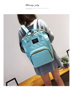 Detail eines hellblauen Oxford-Rucksacks mit gelben Reißverschlüssen und schwarzen Griffen