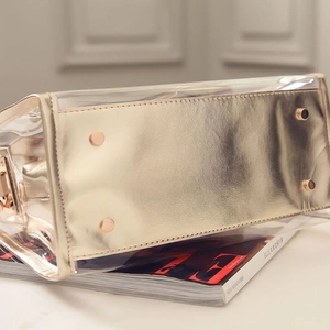 Vue du fond du sac cabas transparent en PVC avec bordure dorée et pieds de protection