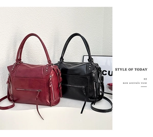 Detail of burgundy and black large PU leather handbags with metal studs and long tassels