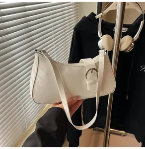 Close-up of white PU leather baguette bag with a large silver buckle and slim strap