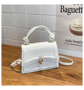 Detail of white PU leather handbag with a unique knotted handle and gold ring buckle