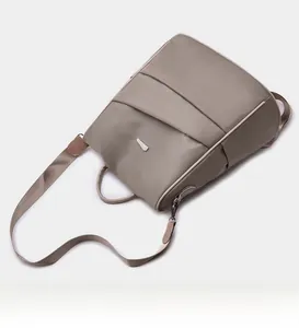 Detailed top-down view of a taupe water-resistant nylon backpack with adjustable straps