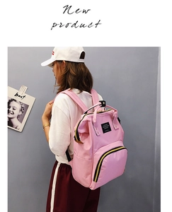 Nahaufnahme des rosa Oxford-Rucksacks mit Tragegriff und schwarzem Logo-Aufnäher