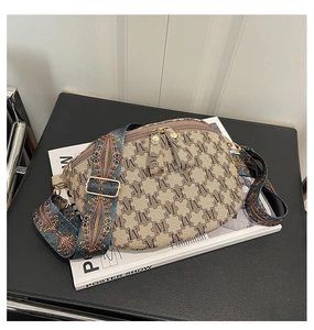 Detail of checkered crossbody bag featuring a woven strap and golden metal hardware