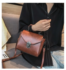Dettaglio di borsa vintage in pelle PU marrone con chiusura a scatto in metallo grigio