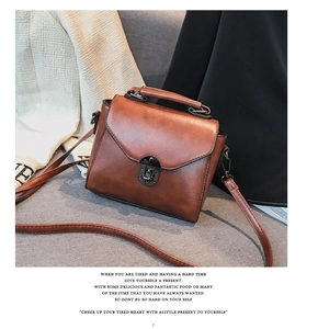 Dettaglio borsa a tracolla marrone vintage con classica chiusura a rotazione in metallo nero