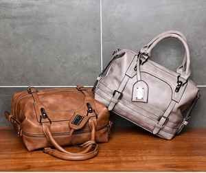 Detail of vintage tote bags in brown and taupe with strap buckles and metal charms