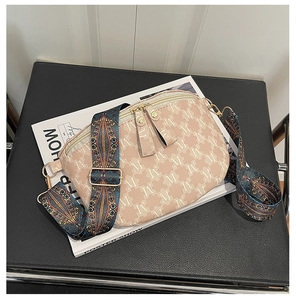 Detailed macro view of pink M-pattern canvas bag with gold zipper and embroidery strap