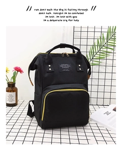 Detail eines schwarzen Oxford-Rucksacks mit gelben Reißverschlüssen und Markenetikett