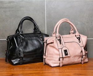 Close-up of leather texture and metallic buckle details on a Boston handbag