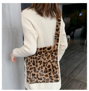 Détail du sac bandoulière en peluche léopard porté sur un pull en maille crème