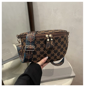 Detail of a brown leather waist bag with monogram pattern and ethnic woven shoulder strap