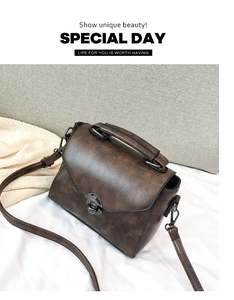 Dettaglio borsa in pelle PU marrone vintage con chiusura a scatto in metallo grigio scuro