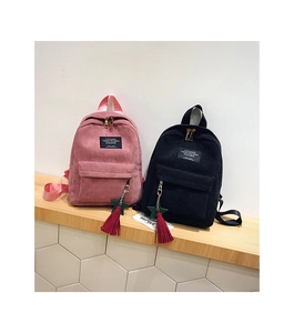 Detailed view of pink and black corduroy mini backpacks with star charm tassels