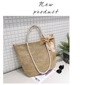 Detail of hand-woven straw tote bag with elegant cream satin bow and rope handles