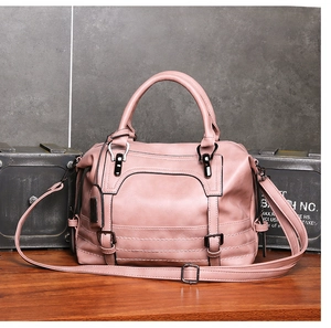 Detailed shot of pink Boston handbag with dual handles and gunmetal gray hardware accents