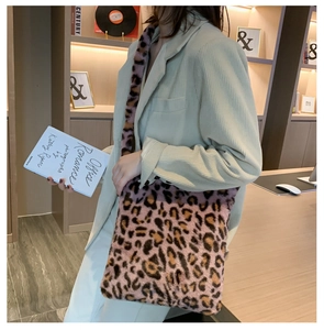 Détail du sac bandoulière en peluche léopard rose porté avec un costume en velours