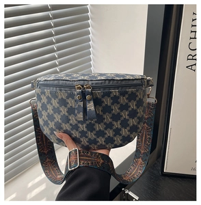 Detail of navy blue crescent bag with yellow jacquard pattern and ethnic woven straps