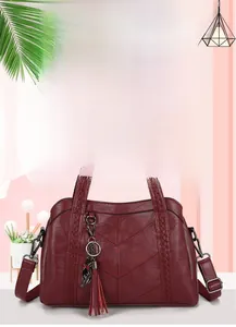 Détail du sac cabas en cuir bordeaux avec surpiqûres en V et bandoulière tressée