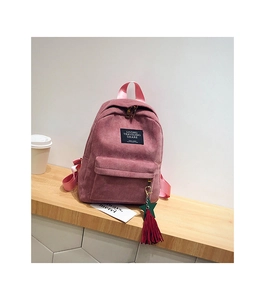 Pink corduroy backpack detail showing ribbon strap and colorful star tassel charm